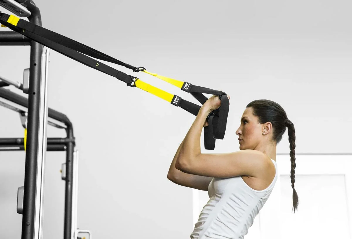 Woman using Connexus with TRX straps
