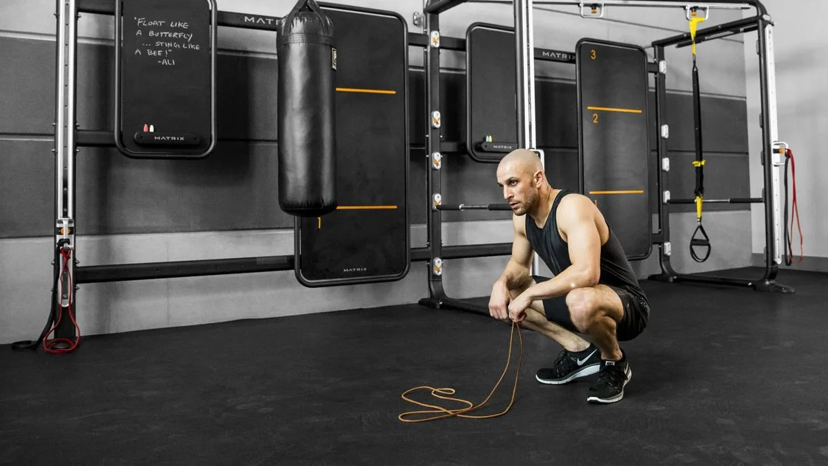 Man holding jump rope crouching beside Connexus