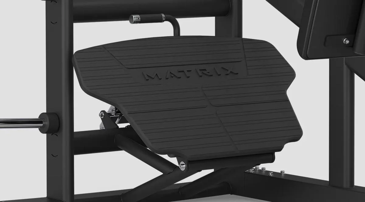 Close-up of the large textured footplate on a Matrix Fitness leg press machine in Matte Black, featuring the Matrix logo.